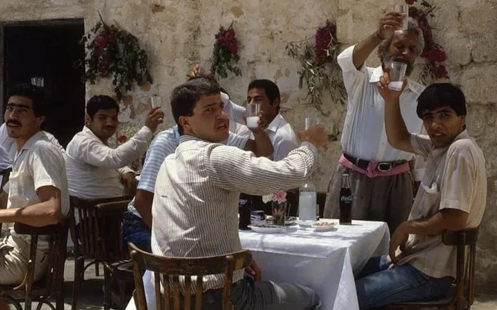 Men sitting at a table and drinking Arak